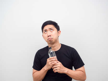 Asian man feeling afraid with water bottle in hand looking up copy spaceの写真素材