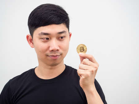 Closeup Asian man looking at bitcoin in his hand and smile face on white backgroundの写真素材
