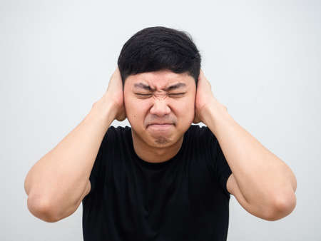 Closeup Thai man feeling annoyed and close his ear by hand on white background