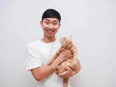 Asian man white shirt happy smile and cheerful carry orange cat look at camera on white backgroundの写真素材