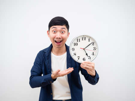 Asian man show clock in his hand happy face get off work concept on white backgroundの写真素材