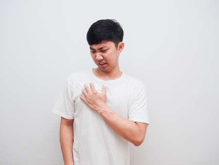 Asian man touch at his chest unhappy face on white background pain conceptの写真素材
