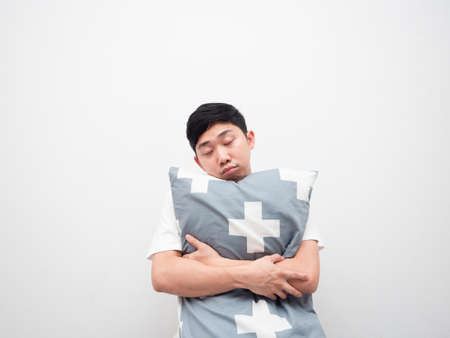 Asian man sleepy face hug pillow on white background lazy conceptの写真素材
