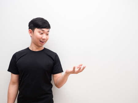 Asian man look at left hand up with happy smile on white background spaceの写真素材