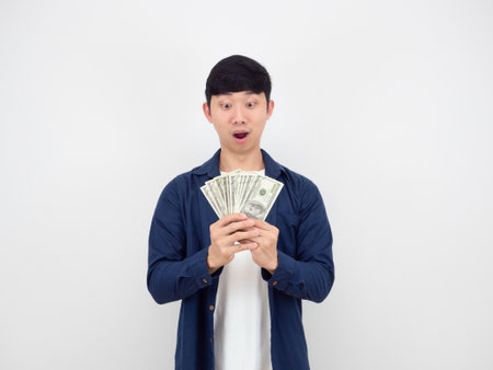 Man looking at A lot of money in his hand feeling amazed say wow on white backgroundの写真素材