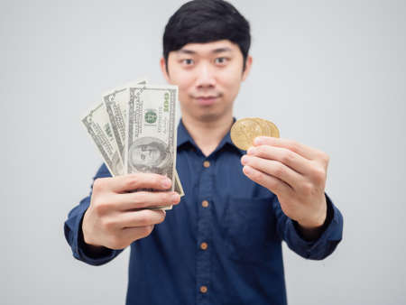 Closeup money and gold bitcoin in asian man smile face on white background digital money conceptの写真素材