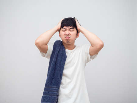 Man with towel feeling sleepy and headache unhappy face portrait white backgroundの写真素材