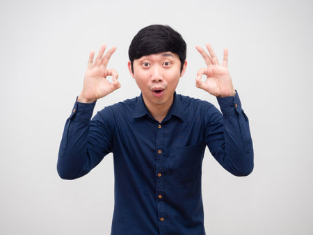 Cheerful man asian hand up ok happy face on white backgroundの写真素材