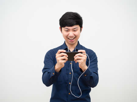 Asian man using earphone play game on mobilephone feeling fun white backgroundの写真素材