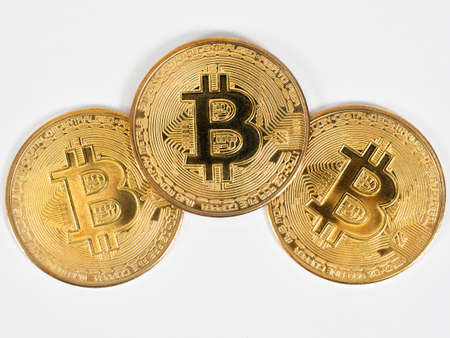 Closeup three golden bitcoins detail on white background