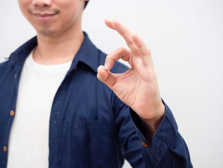 Closeup hand ok of asian man smile face portrait white backgroundの写真素材