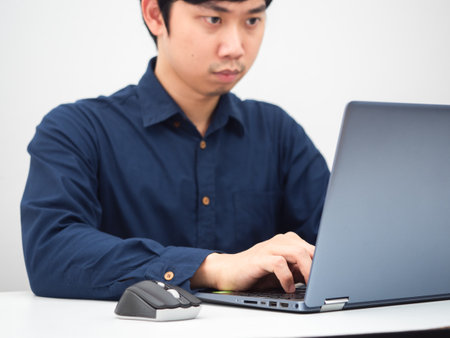Asian man working with his laptop on the table at home