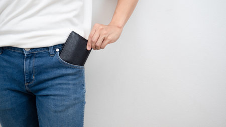 Close up man hand pick up wallet out of jean pocket white background copy space crop shot