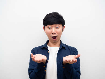 Asian man looking at his empty hand feeling amazed showing product conceptの写真素材