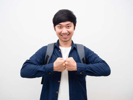 Young man impact fist smile face with backpack portrait white backgroundの写真素材