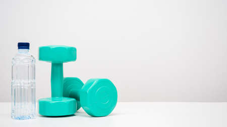 Dumbbell with water bottle on the table white background copy spaceの写真素材