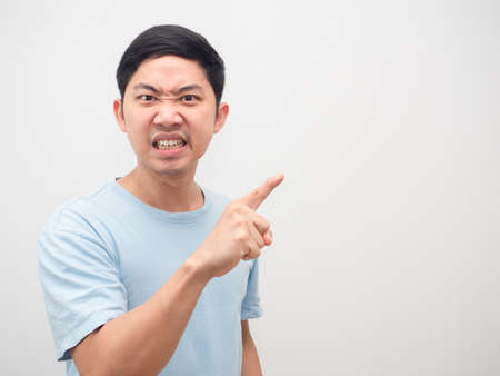 Man angry face looking and point finger at copy space white backgroundの写真素材