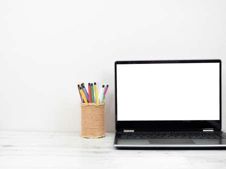Laptop white screen with pencil box on table workspace