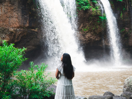 Woman white dress stand at beautiful waterfall in national park fresh nature,Travel concept girl in natureの写真素材