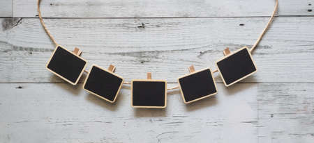 Five small clip chalkboard with rope curve array line on white wood table nature shadow below space,Idea signboard conceptの写真素材