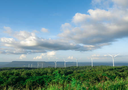 Many wind turbine on the mountain with forest and valley background with the blue sky and cloudy...