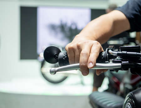 Man hand at handle motorcycle blur background,Hand catch handle bar of motorcycleの写真素材