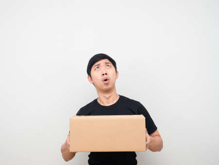 Man holding parcel box feeling amazed looking up at copy spaceの写真素材