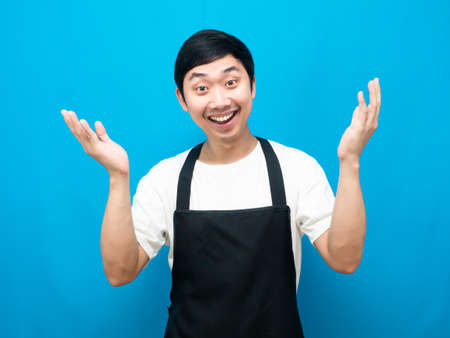 Man wearing apron showing hand up smile faceの写真素材