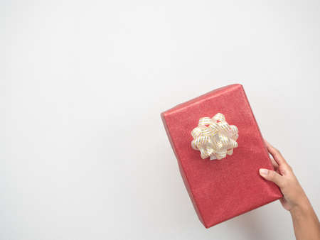 Woman hand holding red gift box on white background copy spaceの写真素材