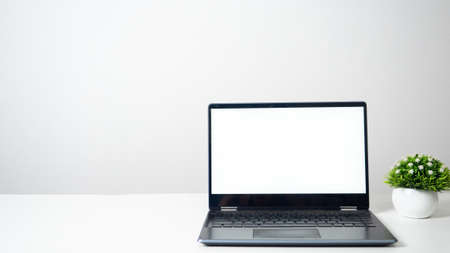 Laptop blank white screen on the table copy space