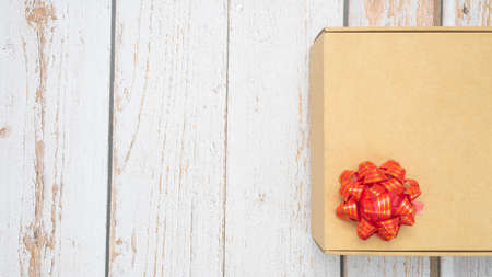 Gift box red ribbon on old wood top view copy space
