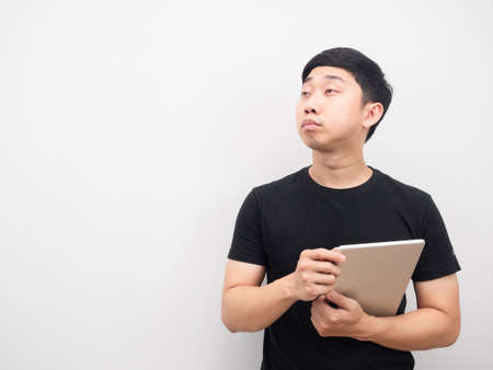 Man holding tablet feeling tried and looking at copy spaceの写真素材