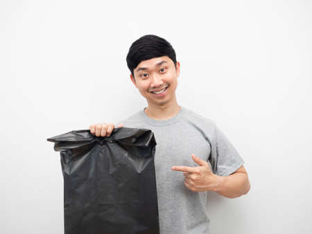 Man smiling and pointg finger at garbage in his hand white background