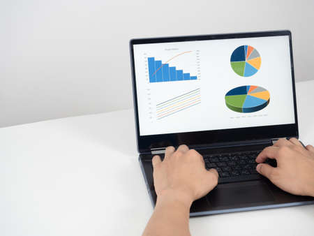 Hand using laptop chart graph business on the table cpoy space