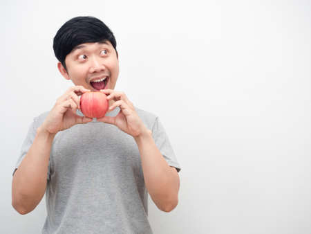 Man grey shirt gesture eatting red apply and looking at copy spaceの写真素材