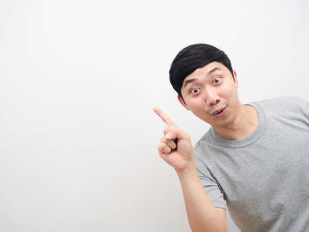 Man grey shirt gesture point finger at copy space cheerful emotionの写真素材