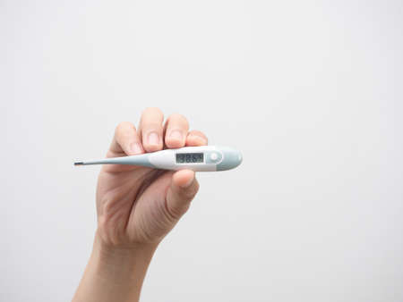 Hand holding thermometer isolated white backgroundの写真素材