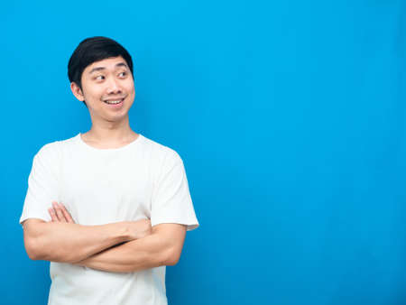 Man white shirt cross arm happy smile looking at copy space blue backgroundの写真素材