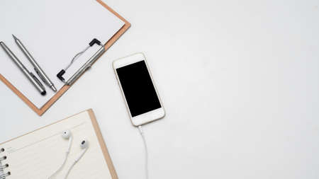 Mobile phone with head phone,wood board document and blank diary top view copy spaceの写真素材