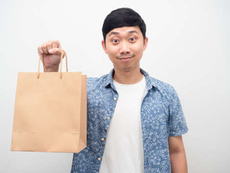 Asian man blue shirt holding shopping bag portraitの写真素材