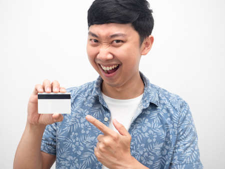 Portrait asian man point finger at credit card in hand happy smile emotionの写真素材