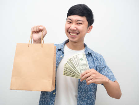 Asian man happiness with shopping,Cheerful man holding a lot of money and shopping bagの写真素材