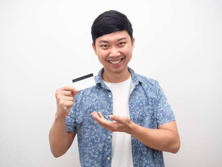 Man blue shirt showing credit card in hand smiling happyの写真素材