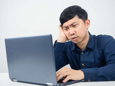 Male employee sitting at office workspace feeling strain looking at laptop