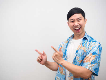 Cheerful man holiday shirt point finger at copy space delighted emotionの写真素材