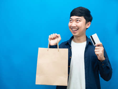 Man feel happy with shopping looking at copy space,Man holding credit card and paper bag