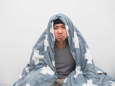 Man wake up at morning cover blanket his body feel bored about sleeplessの写真素材