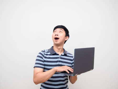 Man striped shirt holding laptop excited looking up copy spaceの写真素材