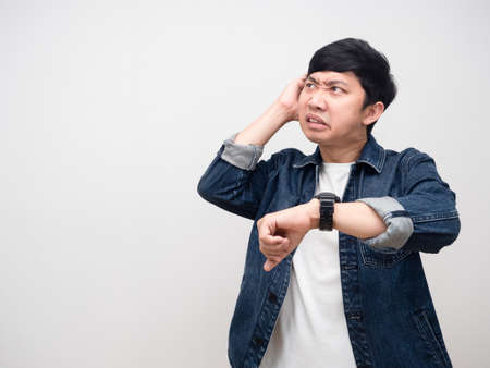 Asian man jeans shirt show watch feels headache looking at copy spaceの写真素材