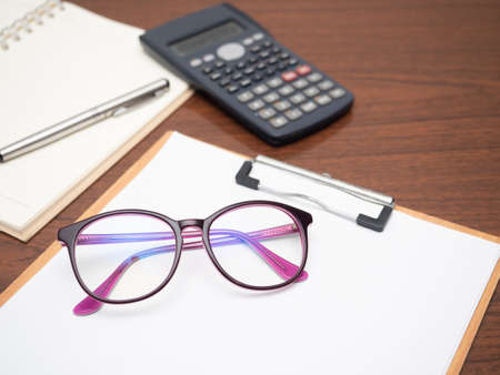 Closeup workspace on table, Document board calculator glasses on tableの写真素材